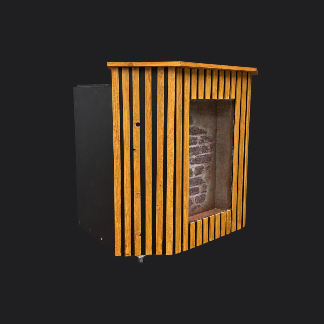 Houten DJ-booth met verticale latten, een zwart zijpaneel en een middenpaneel met baksteenlook, schuin van links gezien.