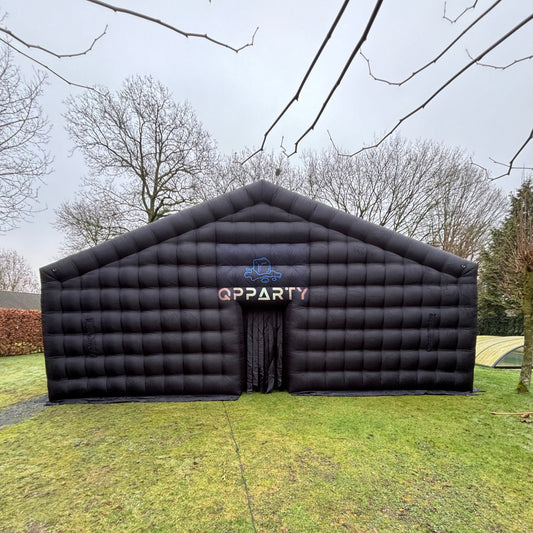 Opblaasbare evenemententent van QPparty op gras, formaat 4×10×10 meter, met ingang aan de voorzijde. Voor grote feesten van 150 mensen. Ideaal voor bedrijfsfeesten.