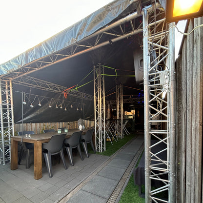 Foto van een QPparty truss tent van 3 meter breed, 6 meter lang en 2,3 meter hoog, met afdekzeilen, schuindak, geïntegreerde trussconstructie, verlichting en speakers. De tent is volledig aanpasbaar.