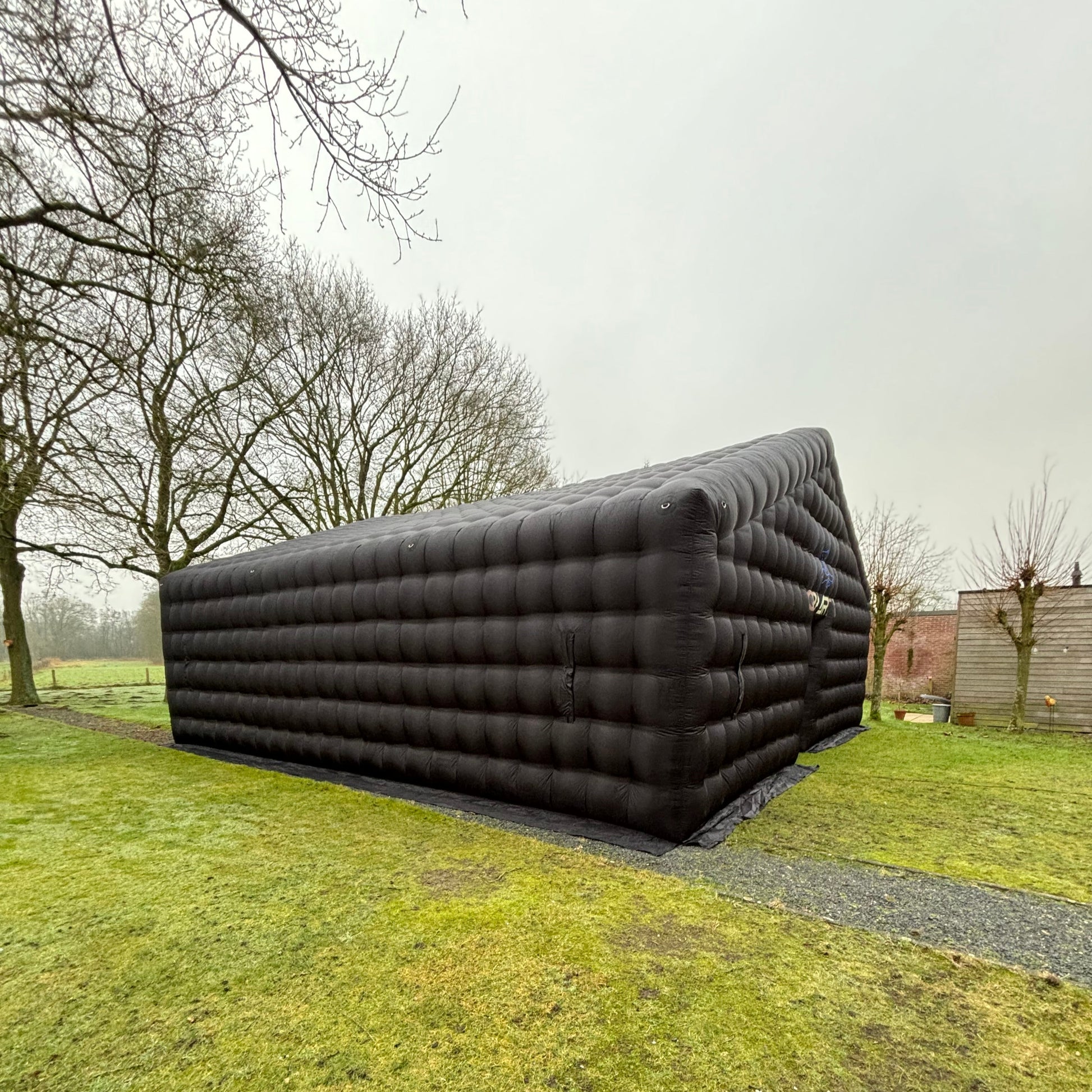 Opblaasbare evenemententent van QPparty op gras, formaat 4×10×10 meter, zijkant. Voor grote feesten van 150 mensen. Ideaal voor bedrijfsfeesten.