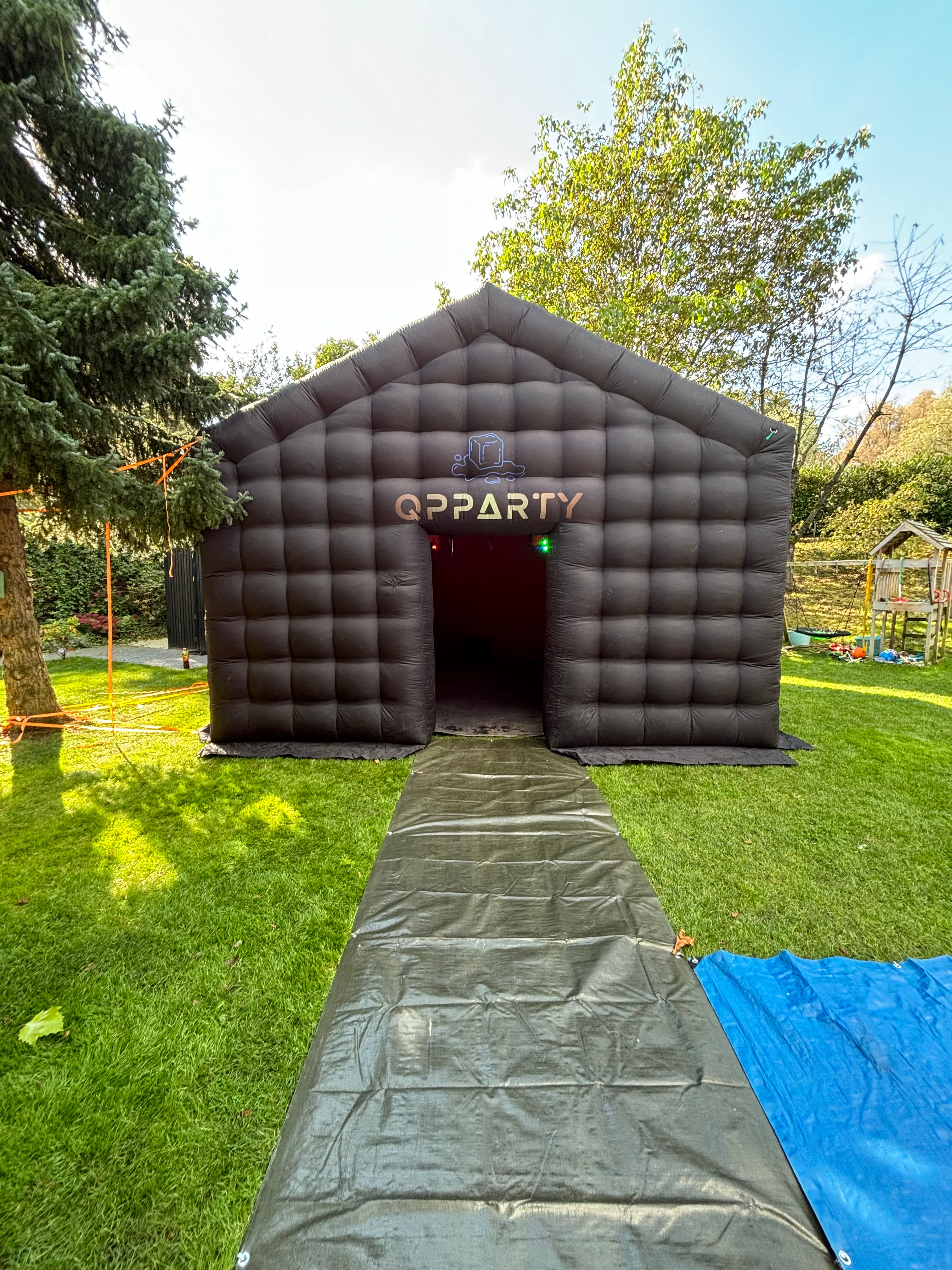 Zwarte grote opblaasbare tent van Qpparty op een grasveld