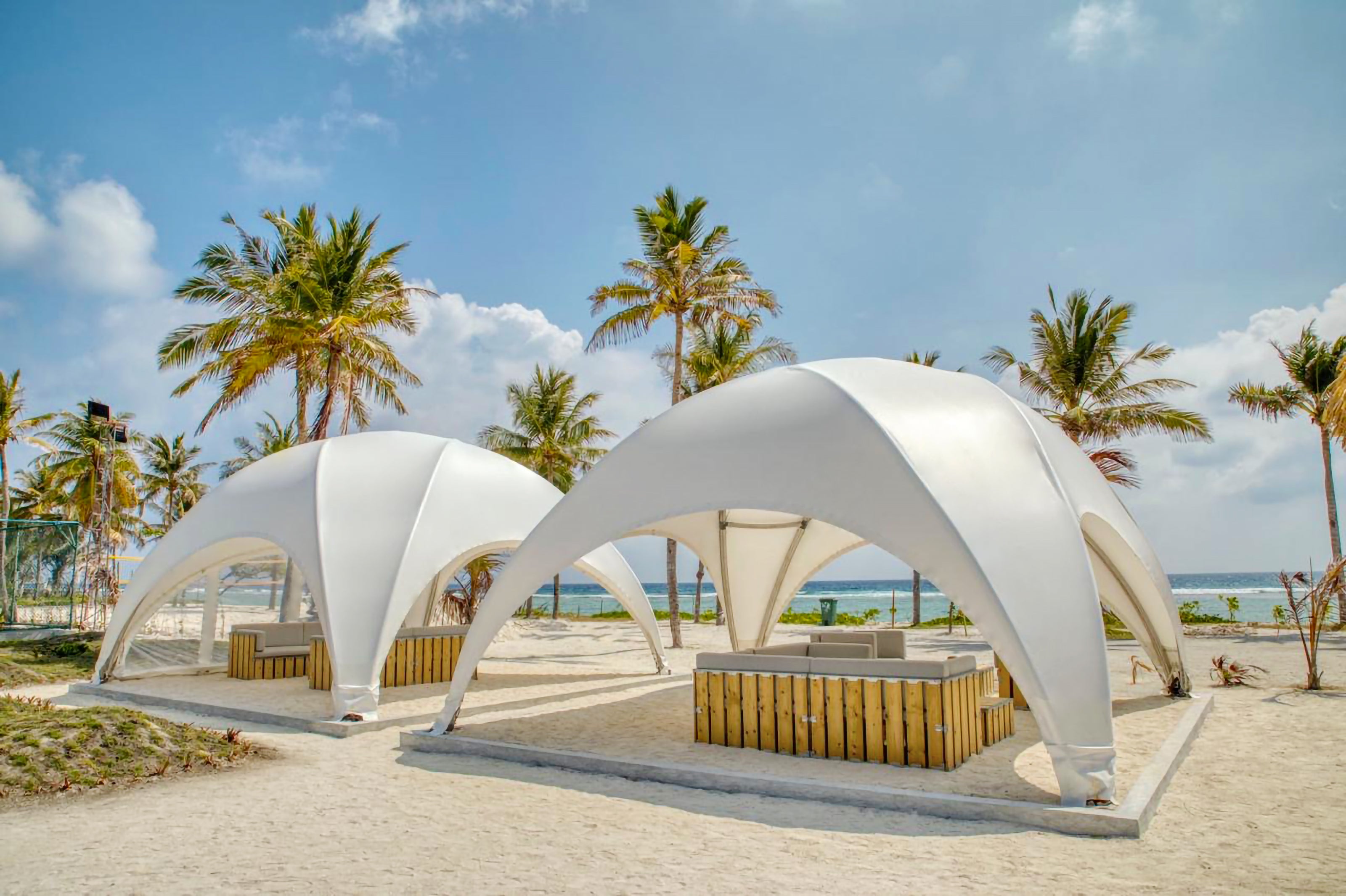 Witte Crossover eventtenten met een lounge opgesteld in een strandomgeving